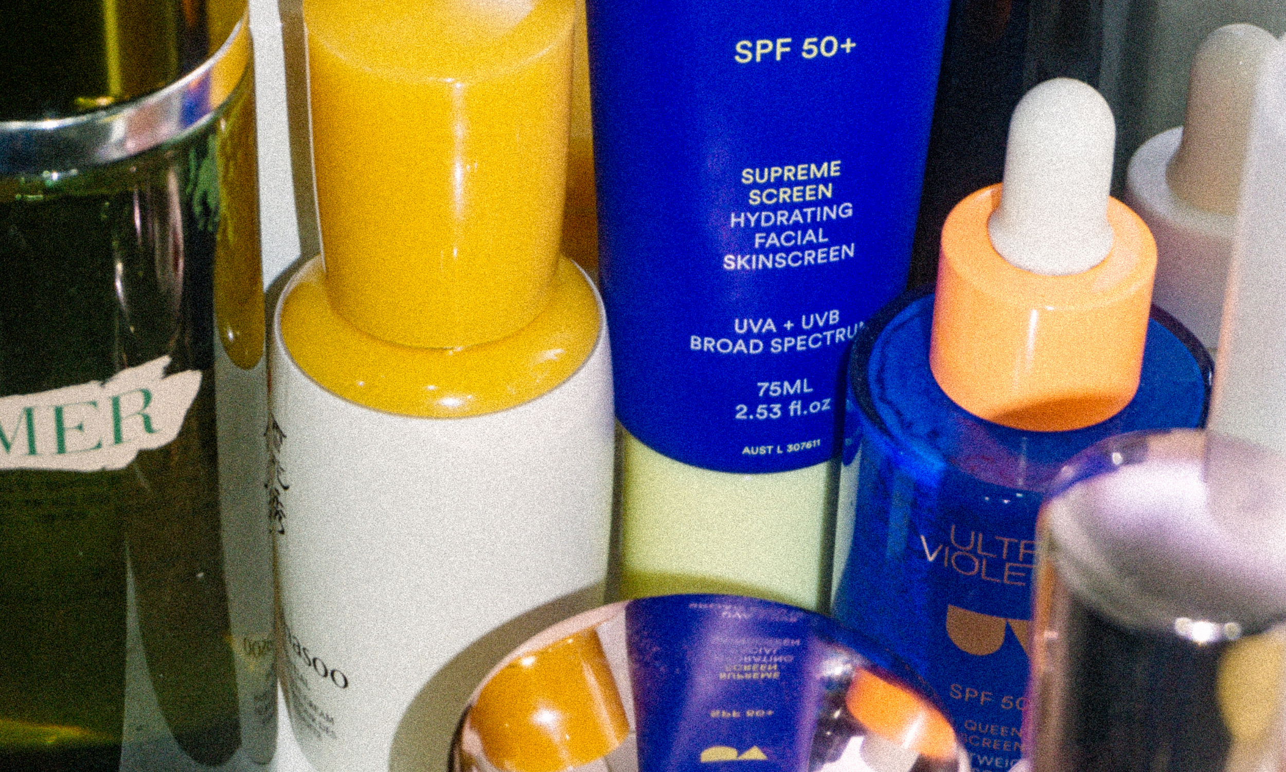 Ultra Violette products stacked with other beauty products on a table.