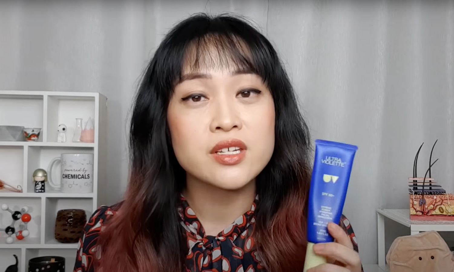 Michelle Wong holding Supreme Screen up next to her face.